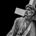 SHOCKING: Soldier DESTROYS Jesus Statue With Sledgehammer…. A black and white statue of Christ carrying a cross with a sorrowful expression