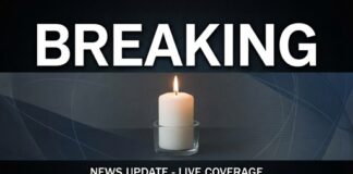 A lit candle with a breaking news banner above it
