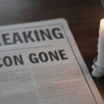 LEGENDARY Songwriter Behind “The Gambler” DEAD at 73… A newspaper with the headline 'BREAKING ICON GONE' next to a lit candle