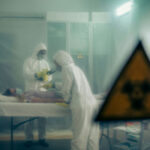 Ebola’s Terrifying ‘PERFECT STORM’ Ignites Global Fear… Two scientists examining a patient with biohazard sign visible.