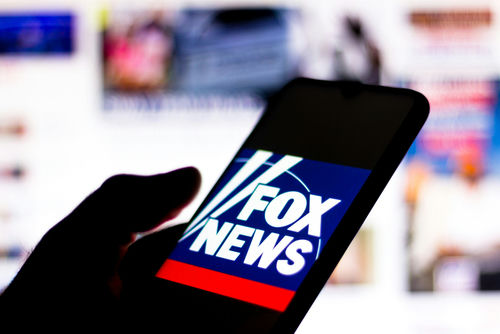 shutterstock1756761830-1jpg Silhouette hand holding phone displaying Fox News logo.