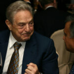 30 Arrests Later, He Murdered—SOROS Prosecutor Let Him Walk… Two men in suits conversing at an event.