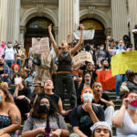 Faith Wars Erupt: Immigration Bill Sparks FURY… Protesters holding signs and chanting on courthouse steps.
