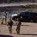 Trump SEIZES Sacred Catholic Land — Pilgrims Blocked… Military personnel and law enforcement officers near a border area with vehicles and barbed wire