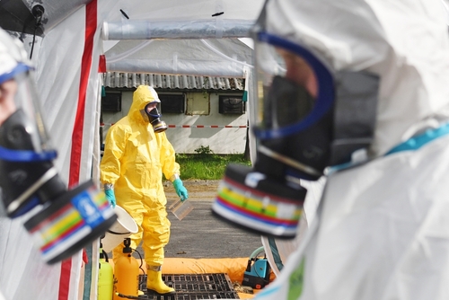 Emergency responders in hazmat suits preparing for a situation