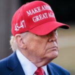 Trump’s ‘HAPPY MEMORIAL DAY!’ Sparks Outrage… A man wearing a red cap with a political slogan, looking serious