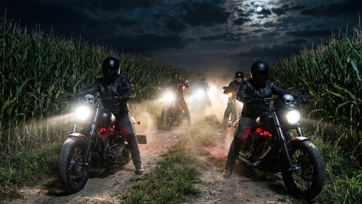 shutterstock_2772792317.jpg Motorcycle riders in a cornfield at night with headlights on