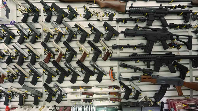 1096565819-1 Gun display wall with various pistols and rifles.