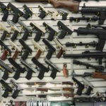 Virginia Crackdown Triggers Ammo Rush Gun display wall with various pistols and rifles.