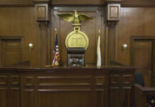 Trusted Rescuer Turns Predator Judges bench in an empty courtroom, scales emblem above.