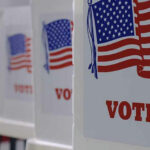 On-Air Voter ID Claim Challenged Voting booths with American flags and VOTE signs