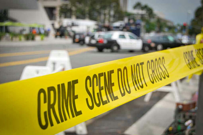 1935517810 Yellow Crime Scene Do Not Cross tape across street.
