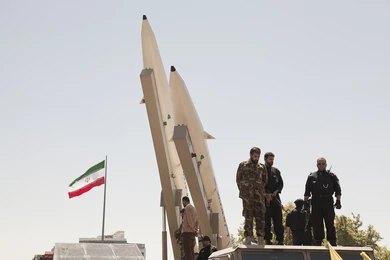 681421708 Soldiers stand beside large missiles at an outdoor display