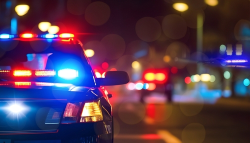 Police,Cars,At,Night.,Police,Car,Chasing,A,Car,At Police car with flashing lights parked on a city street at night