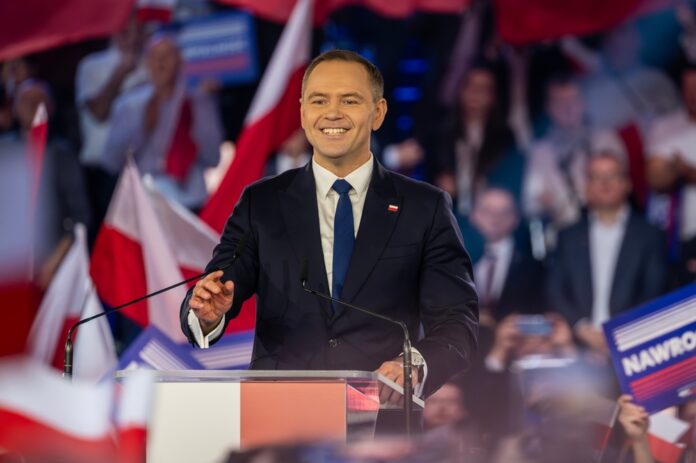 Karol,Nawrocki.,Candidate,For,The,Office,Of,The,President,Of smiling man in suit speaking at podium during rally