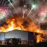 Emergency Powers Meet Independence Day A large building engulfed in flames with fireworks in the sky