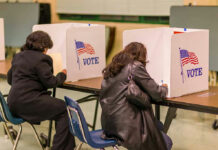 Ballot Scandal Triggers Deportation Fears People voting in booths at a polling station.