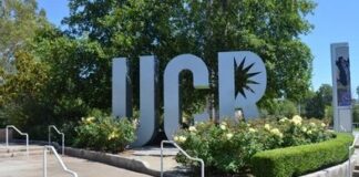 UCR sign sculpture by landscaped flower beds and trees