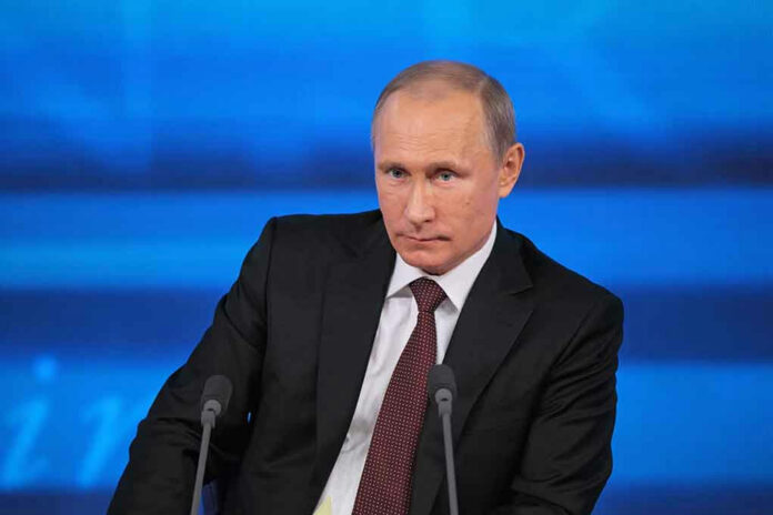 168592763 A serious-looking political figure seated at a press conference with a blue background