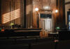 Empty courtroom with sunlight streaming through windows.