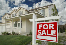 Why Seattle Families Are Selling Their Homes House with For Sale sign in front yard.