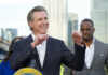 Lawmen Blast Newsom Over Funding Smiling man giving a speech at an outdoor event.