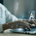 AI Boom Fuels New Inflation Fears Hands typing on laptop with AI holograms.