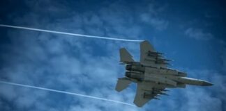Jet fighter flying through a cloudy blue sky leaving vapor trails