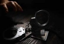 Livestream Murder Shocks Court Handcuffs on cash with a reaching hand in low light