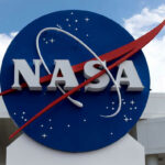 Voyager Reaches Historic Space Milestone NASA logo outside building with blue sky background.