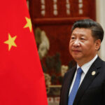 War Warning: China Calls Out Washington, Tehran A man in a suit beside the Chinese flag.