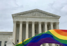 Seattle Weighs LGBTQ Emergency Declaration Supreme Court building with rainbow flag in foreground.