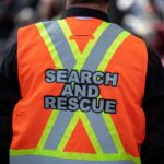 Lake Erie Mystery: Child Vanishes, One Dead Search and rescue worker in an orange reflective vest seen from behind