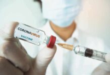 Hidden Files Jolt COVID Origin Fight Healthcare worker holds a COVID-19 vaccine vial and syringe