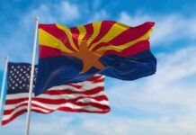 Arizona state flag waving with U.S. flags in background