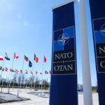 NATO Tensions Reach Breaking Point NATO flags displayed at the headquarters under a clear blue sky