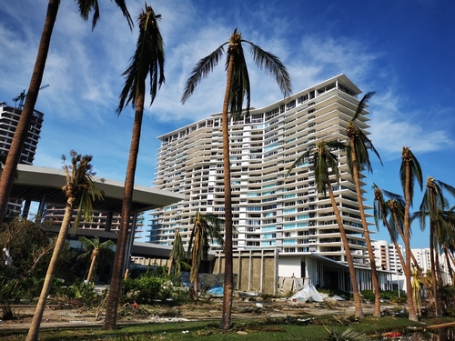 Hurricane,Otis,Left,Chaos,And,Destruction,In,Its,Wake.,Acapulco, Damaged residential building surrounded by palm trees after a storm