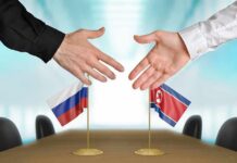 Nuclear Duo Tightens Grip — What’s Coming? Two hands reaching to shake over small Russian and North Korean flags
