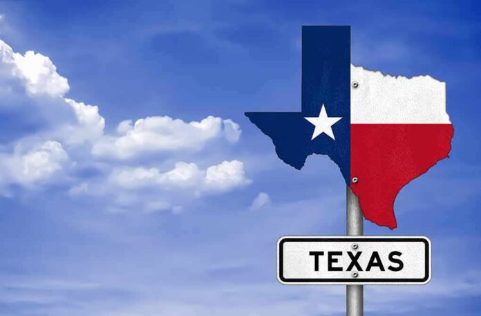 shutterstock_533282275 Texas state-shaped sign with flag colors against a blue sky