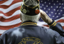 New Hope For America’s Veterans Veteran saluting in front of American flag.