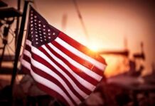 American flag waving at sunset