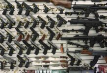 Gun display wall with various pistols and rifles.