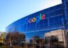 Google's headquarters with reflective glass windows and logo.