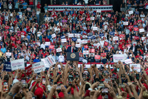 A large crowd at a political rally with signs.