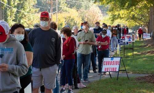 People in line for voting with Curbside Voting sign.