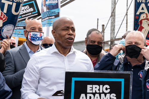 I don't know who they are. Group holding Eric Adams signs.