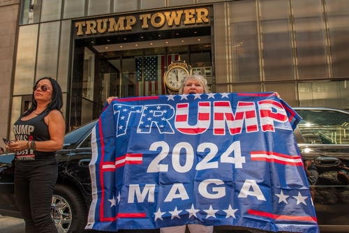 People holding Trump 2024 MAGA banner outside Trump Tower.